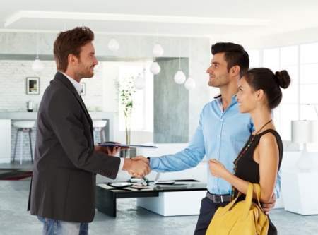real estate agent congratulating a couple on home purchase